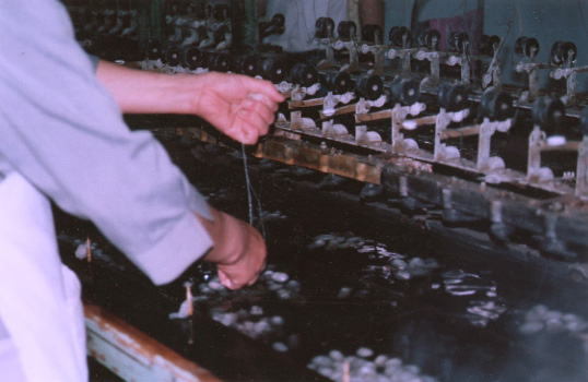 une femme tirant sur les bouts de fil pour les mettre dans la machine
